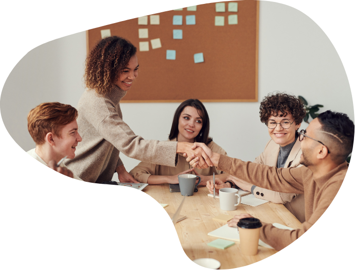 smiling woman shaking hands with person across table full of people