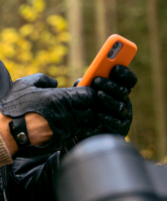 motorcyclist looking at smartphone in hand